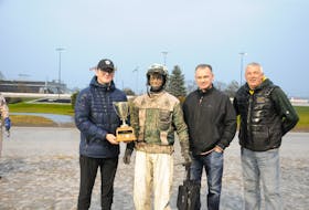 Devin MacDonald, left, grandson of the late Paul MacDonald, presents the Paul MacDonald Memorial Driving Trophy to winning driver Marc Campbell, along with Paul’s son, Danny, and P.E.I. Standardbred Horse Owner's Association president. James Perrot. Contributed