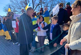 Former Ukrainian president Petro Poroshenko high fives a child at a solidarity event for Ukraine at the Peace and Friendship Park in Halifax on Sunday, Nov. 19, 2023.