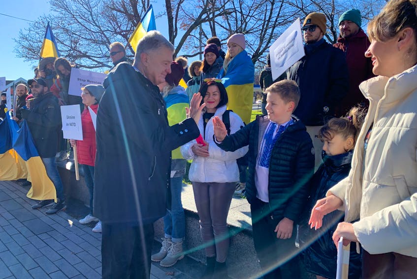 Former Ukrainian president Petro Poroshenko high fives a child at a solidarity event for Ukraine at the Peace and Friendship Park in Halifax on Sunday, Nov. 19, 2023.