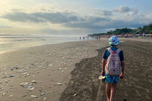 A boy walks on a beach polluted by plastic trash in Bali, Indonesia, April 17, 2023.