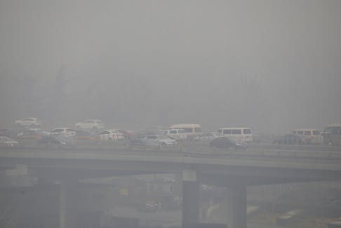 Vehicles drive amid heavy smog in Beijing, China, November 30, 2015.