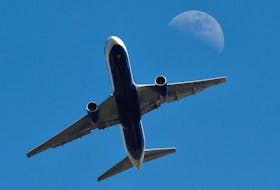 The moon is seen behind an aircraft taking off from Heathrow Airport in west London April 21, 2010. 