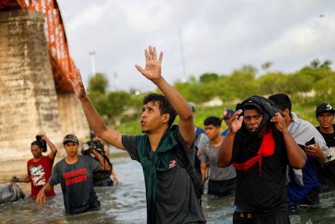 A Venezuelan migrant thanks God as he walks through the Rio Grande river in an attempt to seek asylum into the U. S., as seen from Piedras Negras, Mexico September 30, 2023.