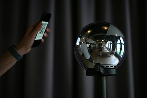 A general view of a mobile phone with a QR code and the biometric imaging device, the Orb of the identity and financial public utility Worldcoin, to create a World ID digital passport, being able to trade in cryptocurrency issued, in Berlin, Germany August 1, 2023.