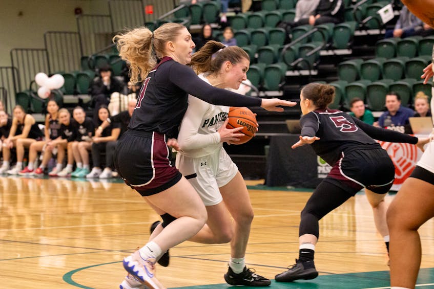 The UPEI Panthers’ Grace Lancaster, white jersey, drives to the basket against the Saint Mary’s Huskies’ Courtney Donaldson, 5, and Mario Steenbakkers, 11, during an Atlantic University Sport (AUS) Women’s Basketball Conference game on Nov. 17. Lancaster scored 26 points in UPEI’s 91-66 road win over the Dalhousie Tigers on Nov. 19. Janessa Vanden Broek/UPEI Athletics • Special to The Guardian