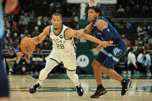 Milwaukee Bucks guard Lindell Wigginton (28) dribbles past Memphis Grizzlies guard Kennedy Chandler (1) in the second half of an NBA pre-season game in Milwaukee on Oct. 1. - Michael McLoone-USA TODAY Sports