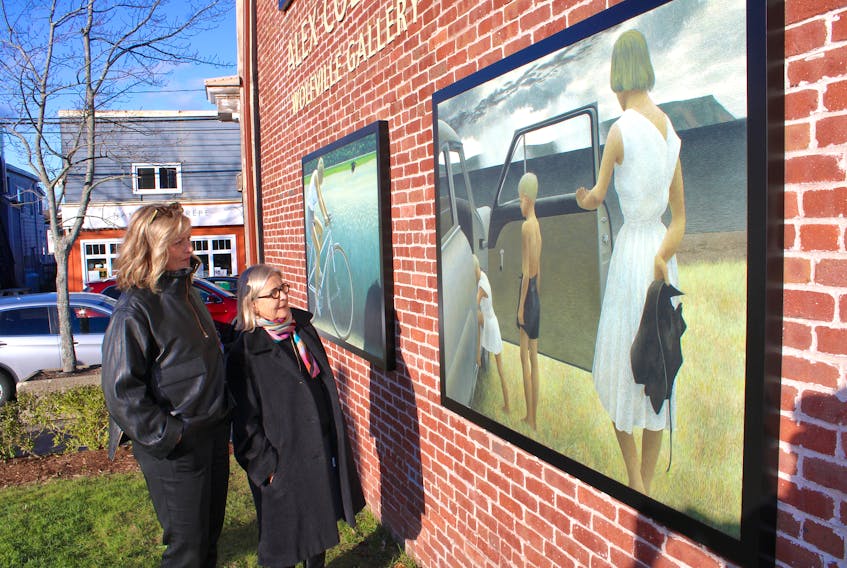 Harvest Gallery owner/curator Lynda Macdonald, left, and Ann Kitz, Alex Colville’s daughter, look at some of the reproduced paintings included in the new Alex Colville Wolfville Gallery. The gallery was officially opened Nov. 19.