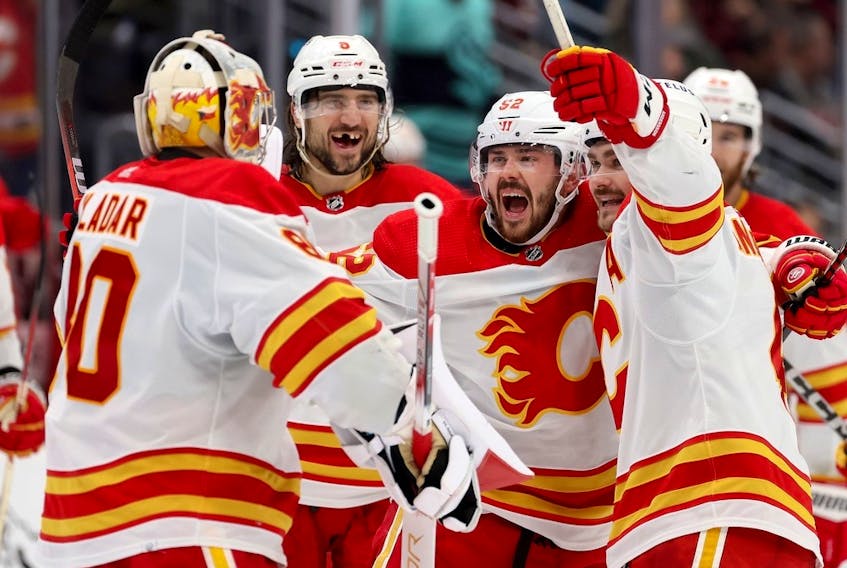 From left, Dan Vladar, Chris Tanev, MacKenzie Weegar and Rasmus Andersson of the Calgary Flames celebrate their overtime win against the Seattle Kraken at Climate Pledge Arena in Seattle on Monday, Nov. 20, 2023 in Seattle.