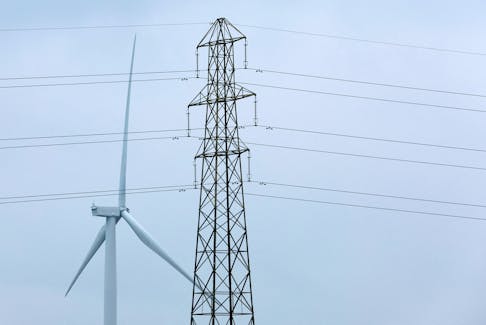 A wind turbine and an electricity pylon are seen in Finedon, Britain, March 30, 2022.