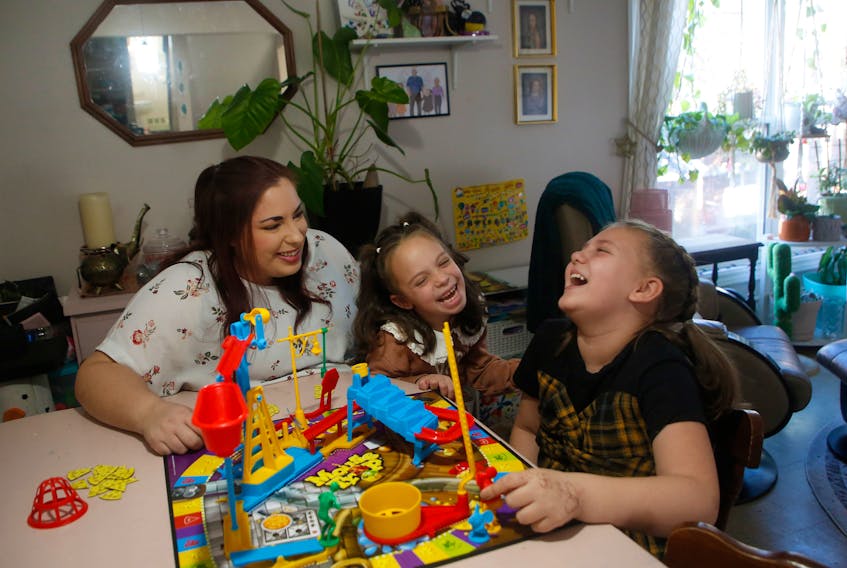 Sam McPhee plays mousetrap with daughters Hazel and Ellie, in their Halifax home November 13, 2013. The family has been renovicted 3 times but now in metro public housing.

TIM KROCHAK PHOTO