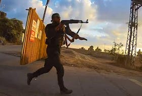 The video, which does not have sound, shows a small clutch of shocked escapees gathered around the compound’s front gate. At 7:08 a.m., according to a time stamp on the video, the group is sent fleeing by the sight of three Hamas fighters sprinting towards the gate and raising their weapons.