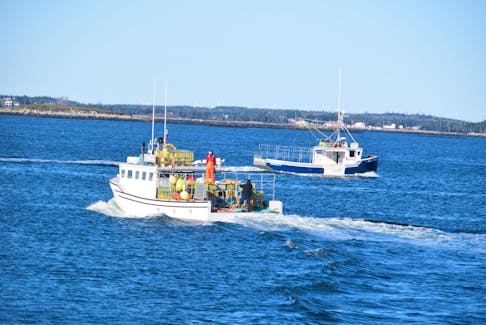 A lobster fishing boat heads out to sea from the West Head wharf on Cape Sable Island while another steams by to the Newellton wharf for a load of gear to set on a previous Dumping Day in LFA 34. KATHY JOHNSON