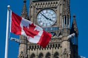 A Canadian flag flies in front of the Peace Tower on Parliament Hill in Ottawa.