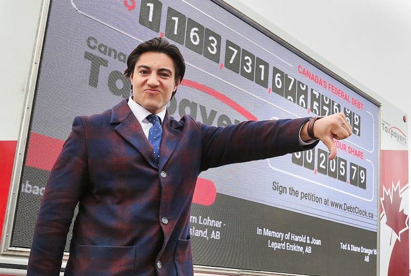  Franco Terrazzano, federal director with the Canadian Taxpayers Federation poses in front of the organization’s Debt Clock on Wednesday, April 20, 2022 during a stop in Windsor.