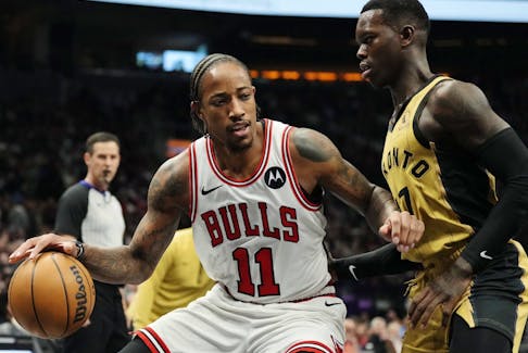 Chicago Bulls' DeMar DeRozan protects the ball from Toronto Raptors' Dennis Schroder during first half NBA basketball action in Toronto on Friday, November 24, 2023.  