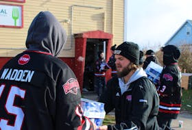 A relay line of Glace Bay Miners U18 AA hockey team members pass packages of evaporated milk into the Glace Bay Food Bank on a snowy Saturday morning. As part of an annual food drive every fall before the holiday season, the team moved in $14,000 worth of milk, potatoes, carrots and turnips provided through donations from either the food suppliers or locals to pay for the goods. LUKE DYMENT/CAPE BRETON POST