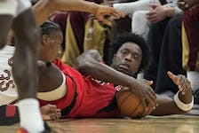 Raptors’ OG Anunoby gathers in a loose ball on the floor while Isaac Okoro reaches for it during last night’s game in Cleveland.  