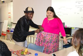 Clothing designer, fashion influencer and NSCC IT generalist student Victor Agara demonstrates on fellow student Aleshia Knockwood how to properly measure fabric so as to be comfortable for moving around and dancing. MITCHELL FERGUSON/CAPE BRETON POST