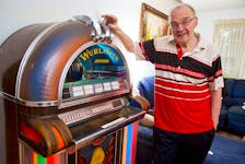Longtime broadcaster Alex J. Walling poses for a photo next to his 1973 Wurlitzer jukebox at his Bedford home on Wednesday night. Walling will celebrate his 50th anniversary of being on the air on Friday.
(RYAN TAPLIN / Staff)