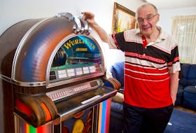 Longtime broadcaster Alex J. Walling poses for a photo next to his 1973 Wurlitzer jukebox at his Bedford home on Wednesday night. Walling will celebrate his 50th anniversary of being on the air on Friday.
(RYAN TAPLIN / Staff)