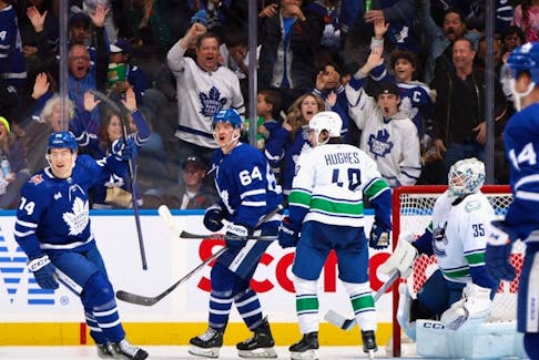 David Kampf of the Toronto Maple Leafs (centre) celebrates his third-period goal against the Vancouver Canucks on Nov. 11, 2023 at Scotiabank Arena in Toronto. The Maple Leafs have gone more than two weeks without a game in Toronto. 