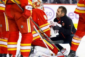 Calgary Flames goaltender Dan Vladar is attended to by medical staff after a collision during the first period at the Scotiabank Saddledome on Monday, Nov. 27, 2023.