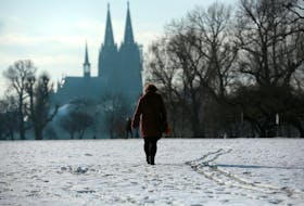 A woman walks through a park covered with snow nearby the Cologne Cathedral amid the spread of the coronavirus disease (COVID-19) in Cologne, Germany, January 24, 2021.