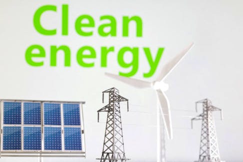 Miniatures of windmill, solar panel and electric pole are seen in front of words Clean energy in this illustration taken January 17, 2023.