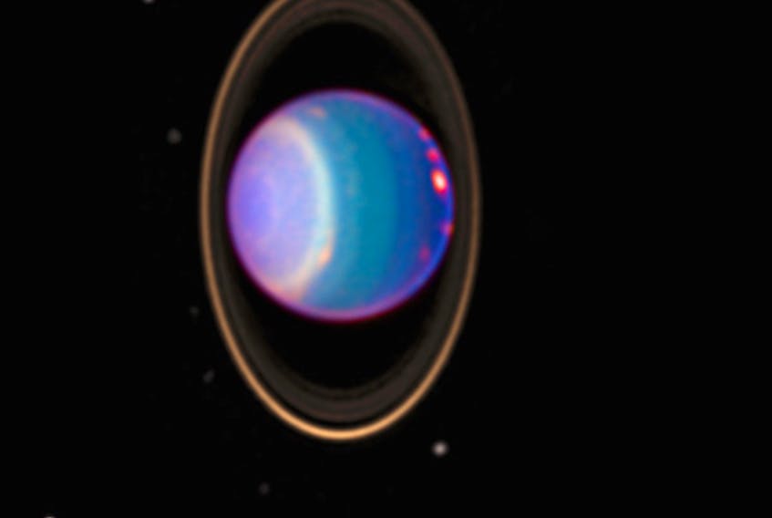 This picture shows Uranus surrounded by its four major rings and by a few of its moons. NASA