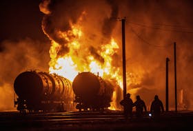 Residents watch tank cars set ablaze following recent shelling at a railway junction in the course of Russia-Ukraine conflict in Donetsk, Russian-controlled Ukraine, October 31, 2023.