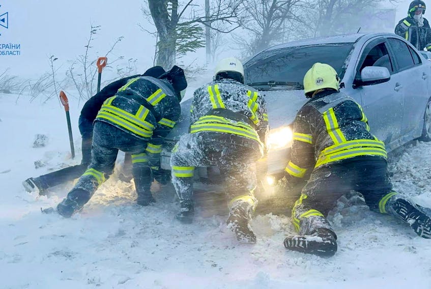 Emergency workers release a car which stuck in snow during a heavy snow storm in Odesa region, Ukraine in this handout picture released November 27, 2023. Press service of the State Emergency Service of Ukraine in Odesa region/Handout via