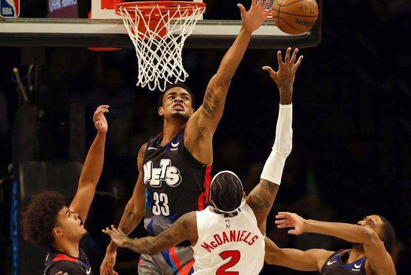 Nic Claxton of the Brooklyn Nets blocks a shot by Jalen McDaniels of the Toronto Raptors.