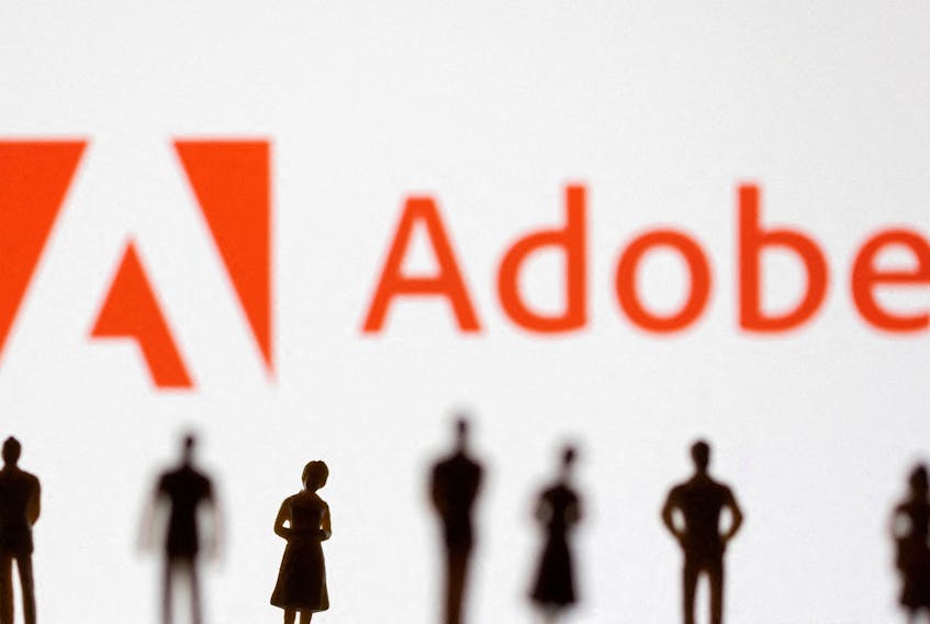 Figurines are seen in front of displayed Adobe logo in this illustration taken June 13, 2022.