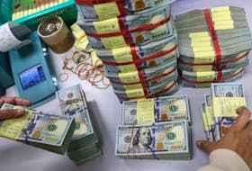 A bank employee gathers U.S. dollar notes at a Kasikornbank in Bangkok, Thailand, January 26, 2023.