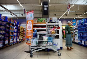 A customer shops next to a sign reading "Anti-inflation challenge, third price cut" at a Carrefour supermarket in Montesson near Paris, France, September 13, 2023.