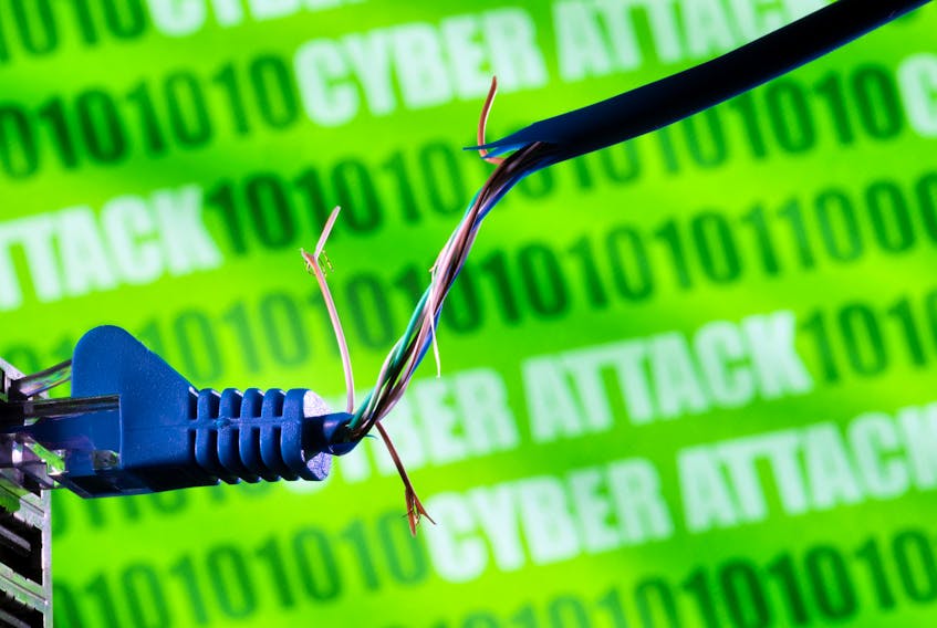 Broken Ethernet cable is seen in front of binary code and words "cyber attack" in this illustration taken March 8, 2022.