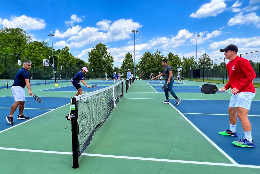 Profession pickleball player Ben Johns (2nd L), currently ranked number one in all three divisions of the sport, plays with his older brother Collin Johns (R), who is ranked number six, in Bethesda, Maryland, U.S. May 17, 2022. Picture taken May 17, 2022. 