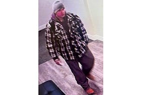 The suspect of the alleged theft on Young Street is described as wearing a black and grey plaid jacket over a grey hoodie, with black pants and a grey toque at the time. - Contributed