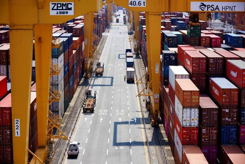 A truck driver stands next to his truck as he gets ready to transport a shipping container at Pusan Newport Terminal in Busan, South Korea, July 1, 2021. Picture taken on July 1, 2021.