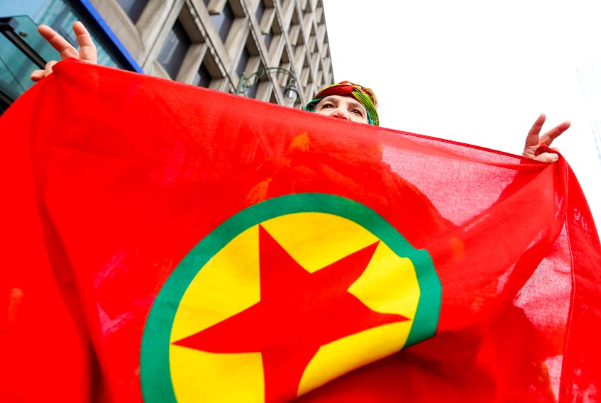 A woman holds a flag of the PKK (Kurdistan Workers' Party) during a demonstration against Turkish President Tayyip Erdogan in central Brussels, Belgium, November 17, 2016.