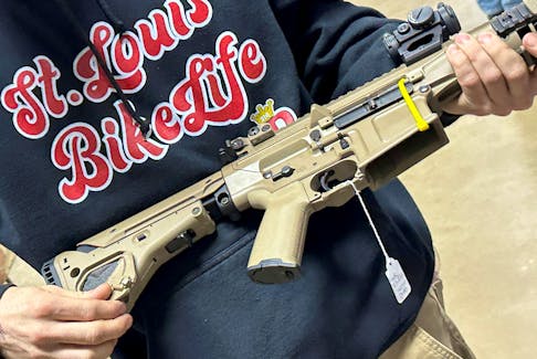 A man examines an AR-10 for sale at the Belle-Clair Fairgrounds & Expo Center Gun Show, after the state of Illinois passed its "assault weapons" ban into law, in Belleville, Illinois, U.S., January 14, 2023.