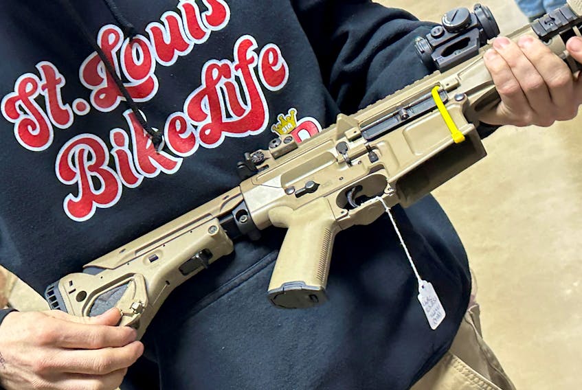 A man examines an AR-10 for sale at the Belle-Clair Fairgrounds & Expo Center Gun Show, after the state of Illinois passed its "assault weapons" ban into law, in Belleville, Illinois, U.S., January 14, 2023.