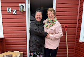 Mildred Lavers, chief of the Northern Peninsula Mi’kmaq Band, gets a hug from Rhonda Martin during the delivery of a food hamper.
