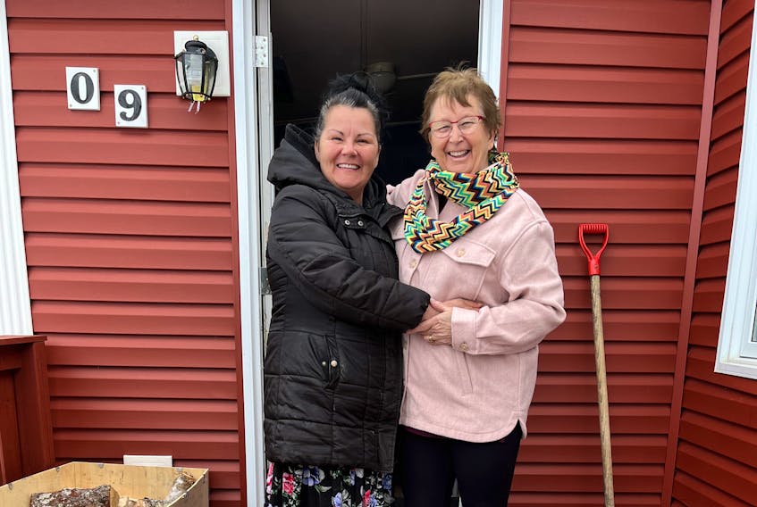 Mildred Lavers, chief of the Northern Peninsula Mi’kmaq Band, gets a hug from Rhonda Martin during the delivery of a food hamper.