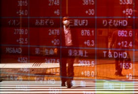 A man is reflected on an electric stock quotation board outside a brokerage in Tokyo, Japan April 18, 2023. 
