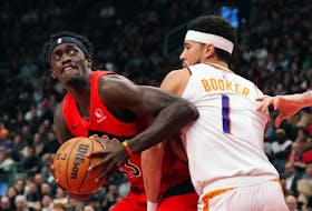 Toronto Raptors' Pascal Siakam (43) tries to get around Phoenix Suns' Devin Booker (1) during first half NBA basketball action in Toronto on Wednesday, November 29, 2023.