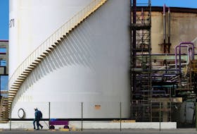 Workers pass in front of a tank at a chlorine-soda plant of the petrochemical company Braskem in Maceio, Brazil January 30, 2020. Picture taken January 30, 2020.
