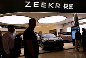 People walk past a booth of Zeekr, Chinese automaker Geely's premium electric vehicle (EV) brand, at a shopping mall in Beijing, China November 3, 2023.