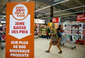 A sign reading "Anti-inflation challenge, third price cut on more than 500 new products" is seen as customers shop at a Carrefour supermarket in Montesson near Paris, France, September 13, 2023.