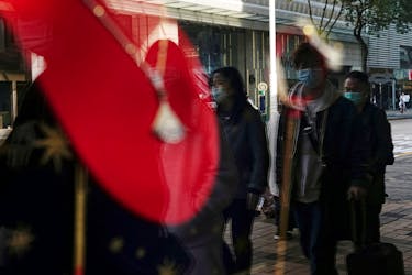 Shoppers walking past a luxury store are seen reflected in a shop window at Tsim Sha Tsui district in Hong Kong, China February 15, 2023.